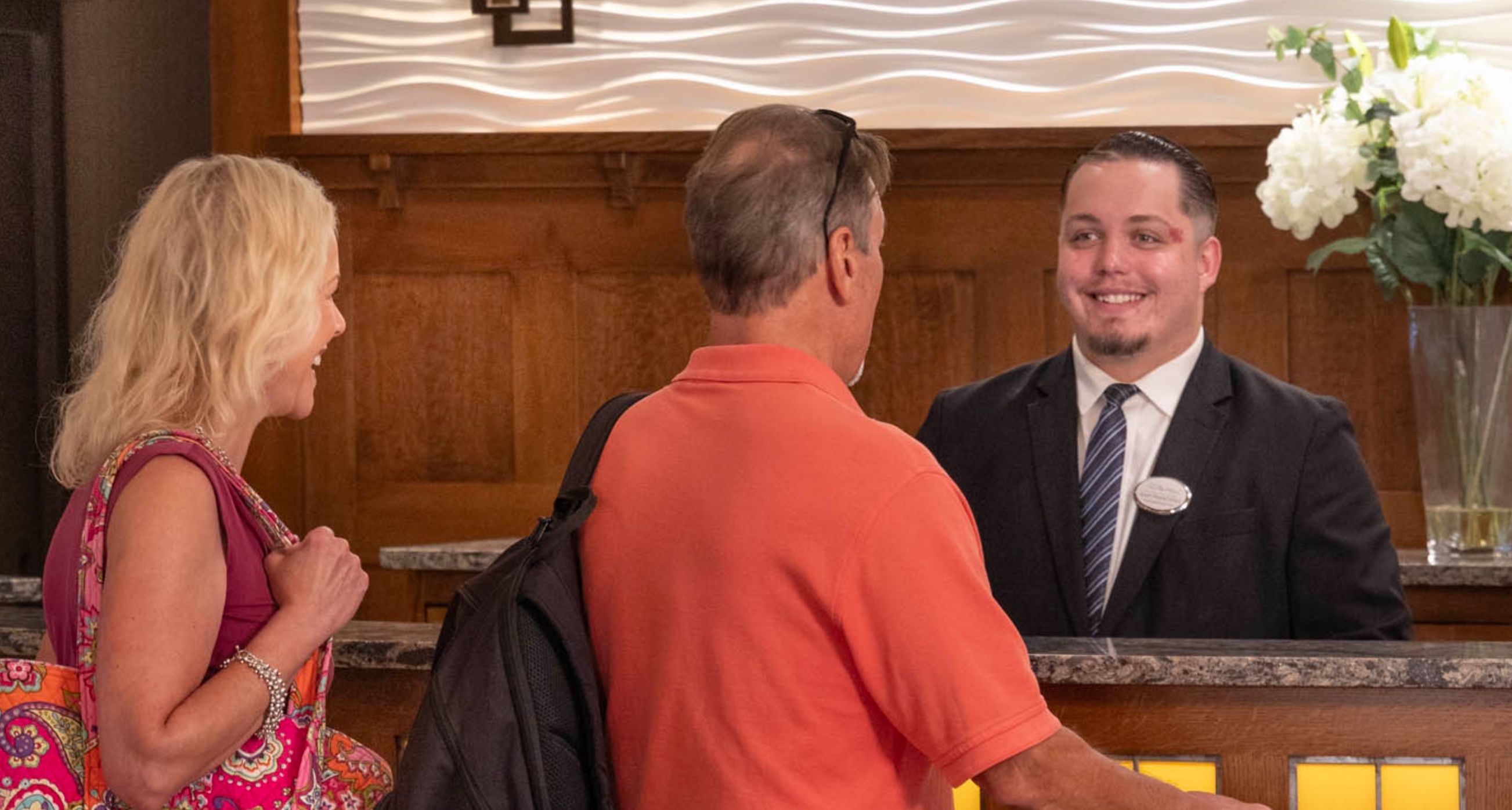A couple approaches a helpful clerk at the front desk at Chautauqua Harbor Hotel